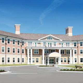A symmetrical institutional building with columns and an entrance.