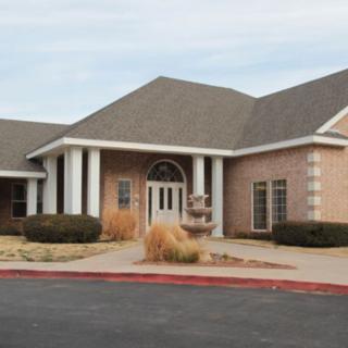 A suburban brick building with a prominent entrance and landscaping.