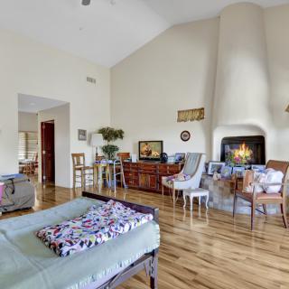 A cozy living room with a fireplace, hardwood floors, and comfortable seating.