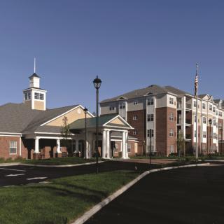 A modern apartment complex with brick and beige exteriors under a clear blue sky.