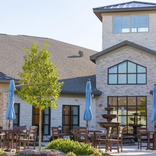 A residential building with outdoor seating and a fountain on the patio.