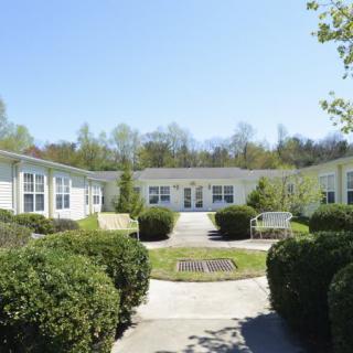A sunny courtyard surrounded by residential buildings and landscaped shrubs.