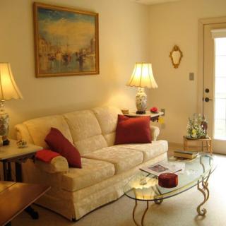 A cozy living room with a beige sofa, decorative pillows, and ambient lighting.