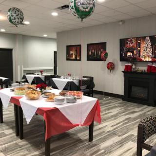 A festive indoor space decorated for a Christmas party with tables set up and holiday decorations.