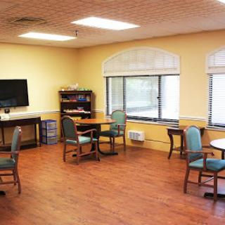 A bright and inviting interior space featuring tables, chairs, and a television.
