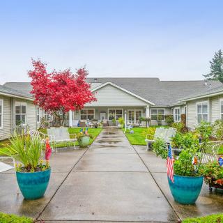 A well-maintained garden area with potted plants leading to a residential building.