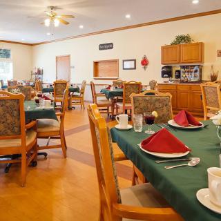 A neatly arranged dining area with tables and chairs set for a meal.