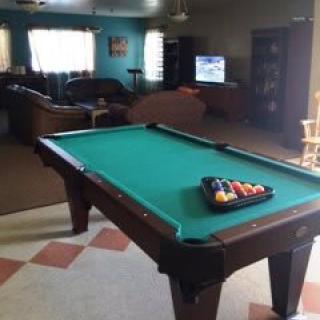 A cozy game room featuring a pool table and seating area.