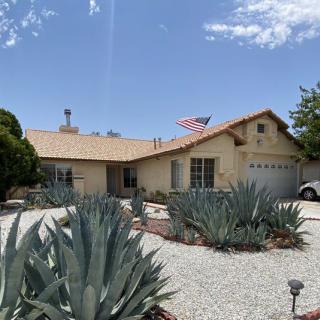 A suburban house with desert landscaping featuring succulents and an American flag.