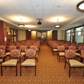 A spacious conference room filled with neatly arranged chairs, ready for an upcoming meeting.