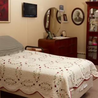 A cozy, vintage-style bedroom with a quilted bedspread and wooden furniture.