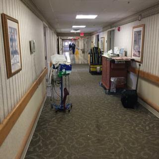 A hallway in a healthcare facility featuring medical equipment and a warm interior design.