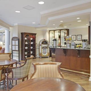 A cozy cafe interior with wooden furniture and a coffee station.