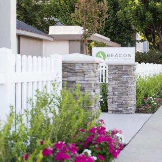 A scenic pathway lined with a white fence and vibrant flowers.