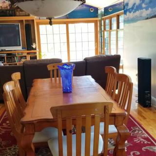 A cozy dining and living area with wooden furniture and a decorative vase on the table.