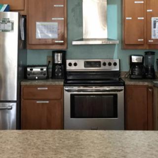 A modern kitchen with stainless steel appliances and wooden cabinetry.