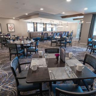 A quiet and neatly arranged restaurant dining area with tables set for service.