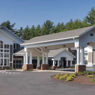 Modern building with a welcoming entrance and landscaped driveway.