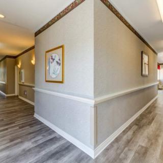 A modern hallway with light-colored walls, decorative lighting, and framed artwork.