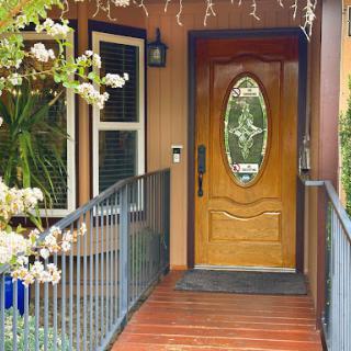 A welcoming entrance featuring a wooden door and beautiful plant decor.