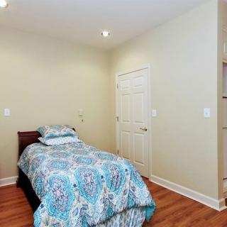 A minimalist bedroom featuring a single bed with colorful bedding.