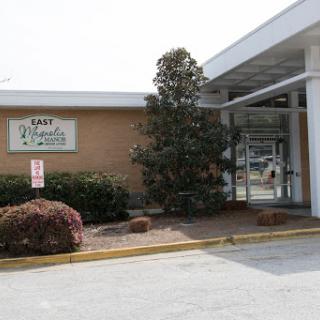 The entrance to a commercial building featuring landscaping and clear signage.