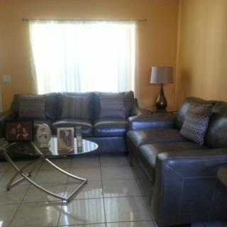 A cozy living room with a large sectional sofa, modern coffee table, and a lamp by the window.