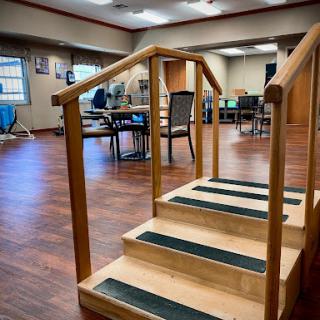 A set of wooden stairs designed for rehabilitation or exercise, located in an indoor facility.