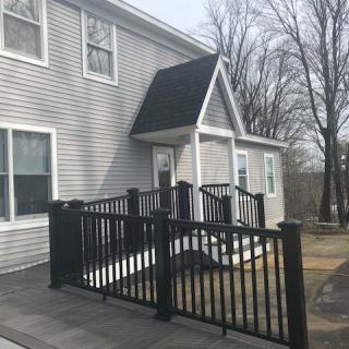 A house with a ramp and black fence at the entrance.
