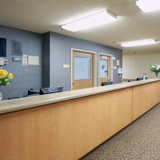 A modern reception area with a long desk and closed doors in the background.