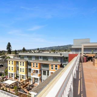 View of colorful apartment buildings and a rooftop terrace under a clear blue sky.