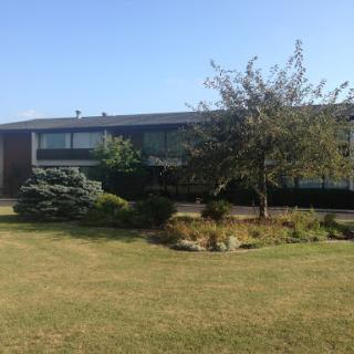 A modern building surrounded by a well-maintained garden and lush greenery.