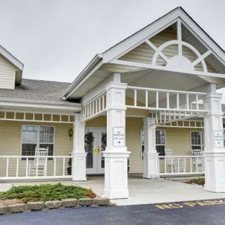 A residential building with a covered entrance and decorative columns.