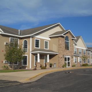 A residential building with a stone facade and large windows under a clear blue sky.