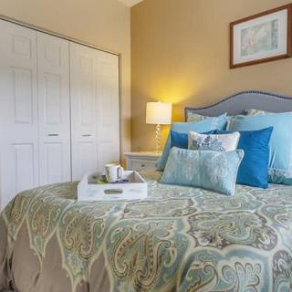 A cozy bedroom with elegant bedding and soft lighting.