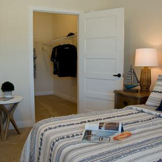 A cozy bedroom with an open closet and neatly arranged decor.