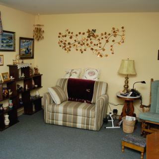 Cozy living room with armchair and decorative shelves.