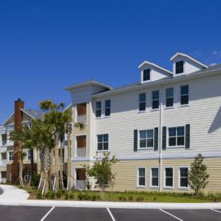 A modern apartment building with a well-maintained exterior under a clear blue sky.