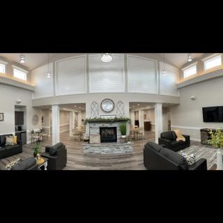A spacious modern living room with a central fireplace, surrounded by sofas and elegant decor.