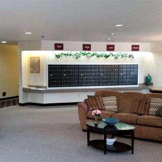 A spacious lobby with a seating area and multiple mailboxes.