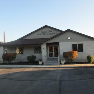 A serene view of a building at sunset, showcasing minimal landscaping and an inviting entrance.