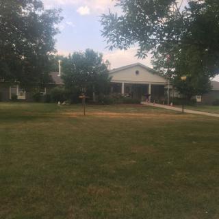A peaceful suburban home with a well-kept lawn and ample trees.
