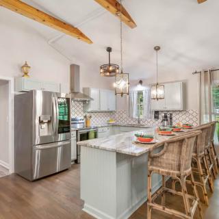 A modern kitchen with a large island, bar stools, and stainless steel appliances.