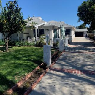 A sunny day at a cozy residential house with a well-maintained lawn and driveway.