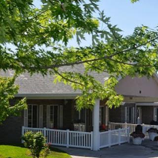 A charming residential house surrounded by lush green trees and a welcoming porch.