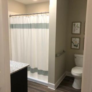 A clean and modern bathroom with a shower curtain, toilet, and sink.