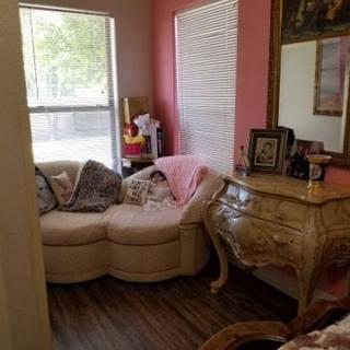 A cozy living room corner with a sofa, dresser, and mirror.