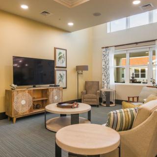 A cozy living room with modern furniture and a large television.