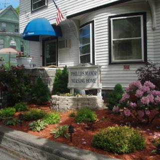 A charming house with a beautiful garden, featuring colorful flowers and an American flag.