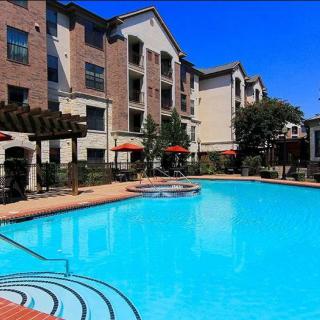 An apartment complex with a large outdoor swimming pool.